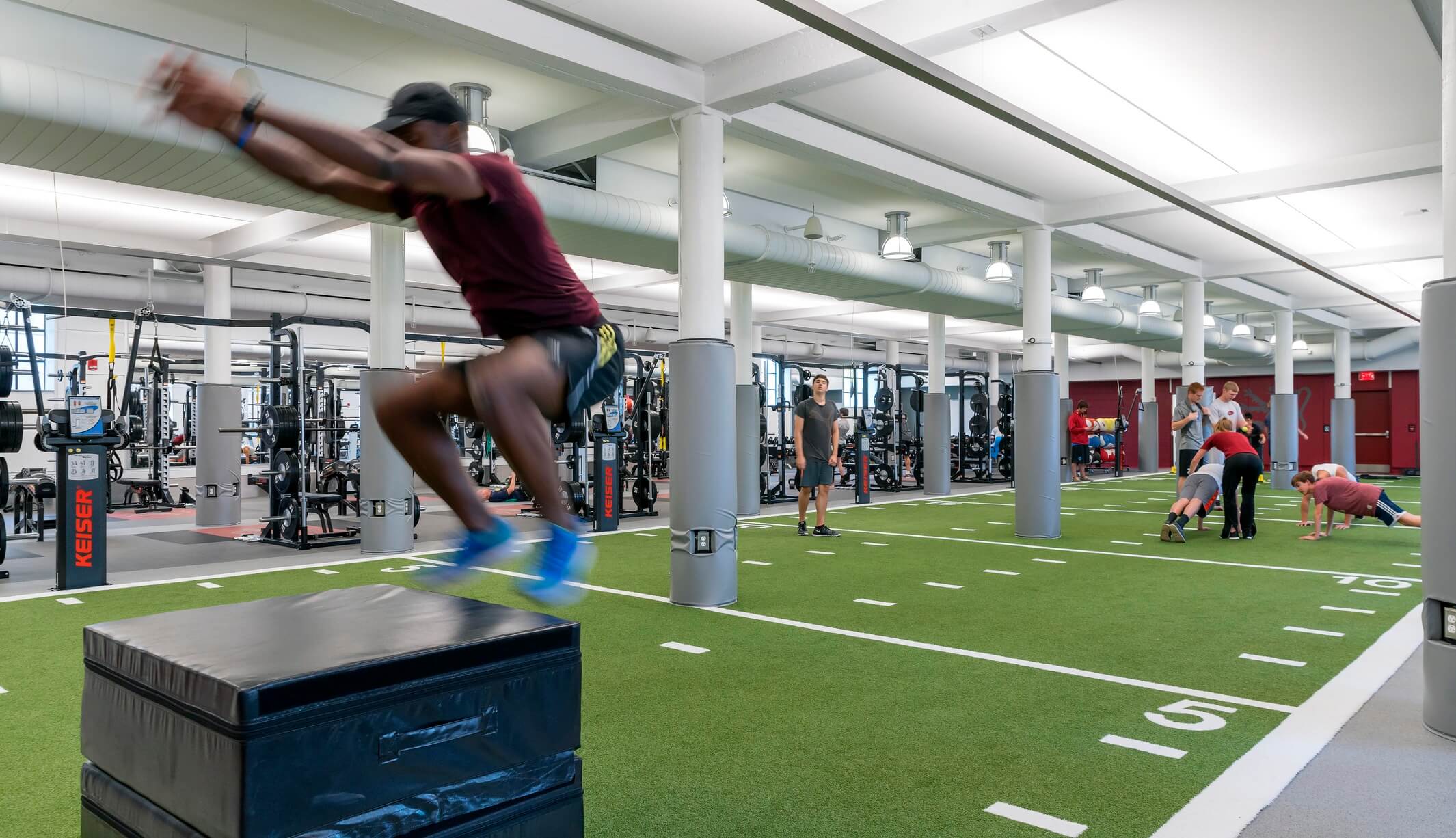 athlete doing a box jump in fitness center