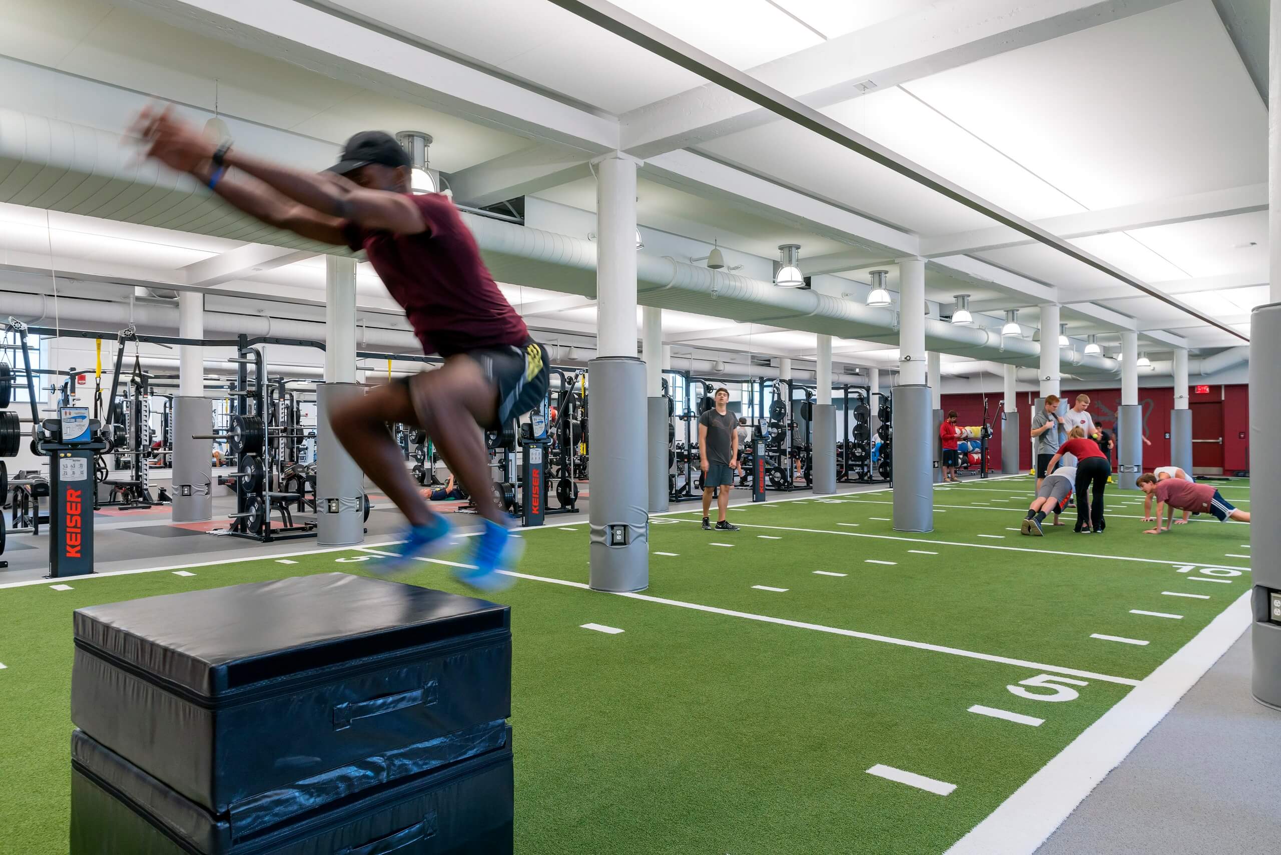 athlete doing a box jump in fitness center