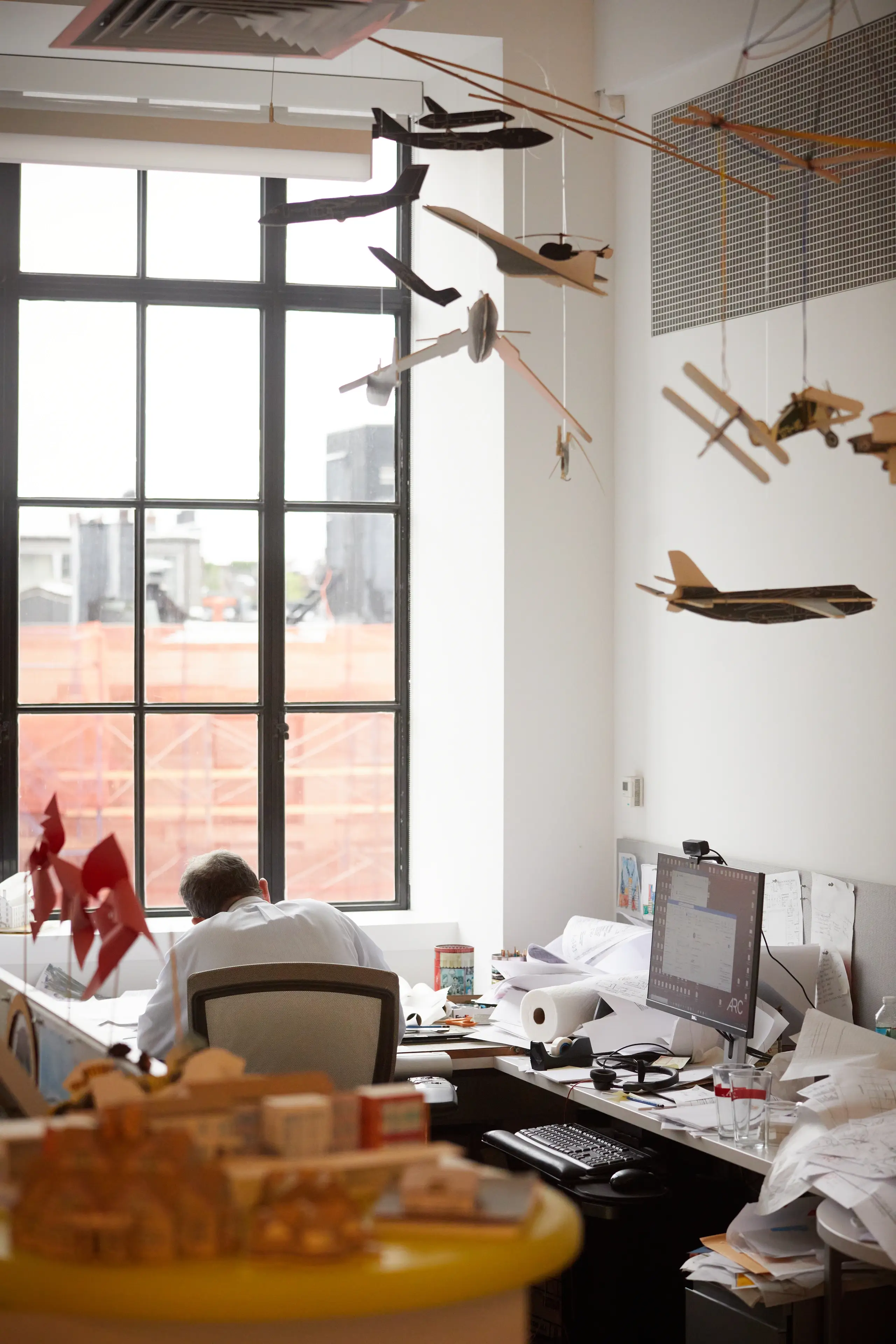 Model airplanes hang from ceiling above team members desk